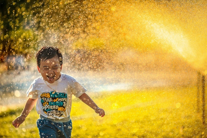 a man running through a sprinkle of water